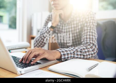 Close-up image of developer looking at programming code on laptop and searching for mistakes Stock Photo