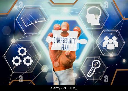 Text sign showing Cybersecurity Plan. Business idea Techniques of protecting computer and system from attacks Hand Holding Jigsaw Puzzle Piece Stock Photo