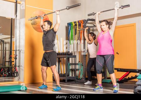 Athlete people doing press exercise with bar without weights in the gym Stock Photo