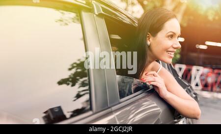 Confident young Hispanic brunette woman looking at train carriage on station platform Stock Photo