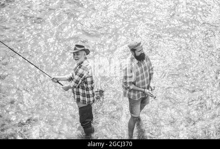 Believe in Team. rural getaway. hobby. wild nature. two happy fisherman with fishing rod and net. father and son fishing. Poaching. Big game fishing Stock Photo