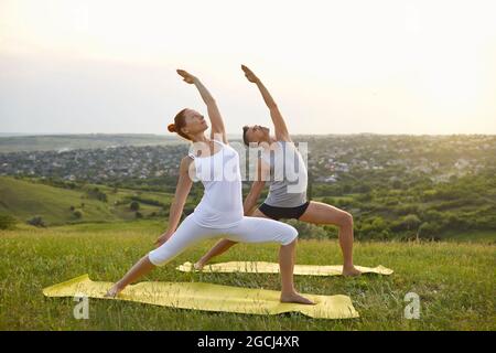 Adult couple doing balance yoga in countryside Stock Photo