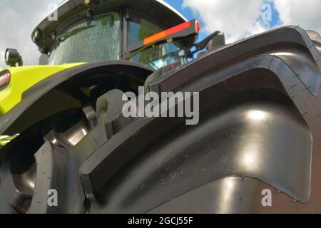 Low angle view of a new farm tractor with a close-up of an agricultural tractor tire. Stock Photo