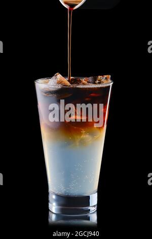 Pouring puer in tonic refreshing drink isolated on black background Stock Photo