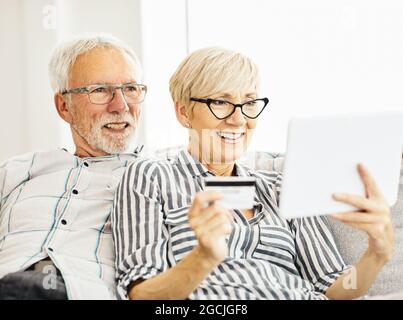 senior couple happy tablet together man woman shopping credit card buying order purchase online pay Stock Photo