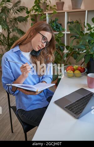 Female student wearing glasses and using laptop Stock Photo