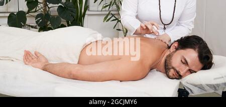 Reflexology. Treatment of back pain and tightness with acupuncture needles for a male patient Stock Photo