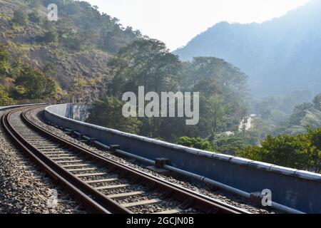 Train tracks going through the forest and mountains captured in Thenmala, Kerala, India Stock Photo