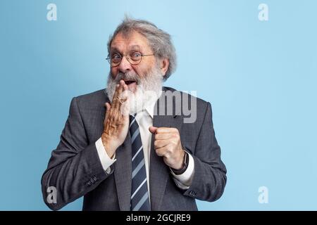 Crazy professor, teacher, gray-headed bearded man posing isolated on gray studio background. Concept of professional occupation, job, education, funny Stock Photo