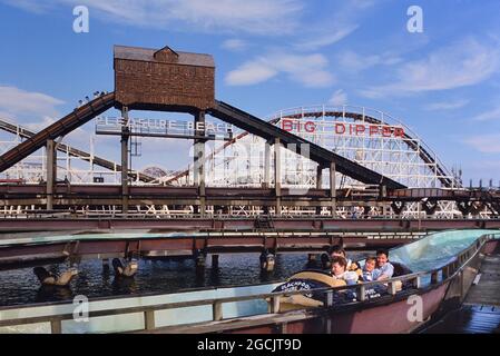 The log flume with the big dipper in the background, Blackpool Pleasure Beach, Lancashire, England, UK. Circa 1980's Stock Photo