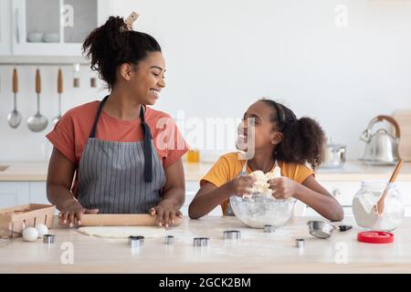 Joyful african american mother and daughter baking together Stock Photo