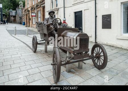A cyclist looks at the Sculpture (2018) in Fort William commemorating Henry Alexander Jr, who drove a Model T Ford to the peak of Ben Nevis in 1911. Stock Photo
