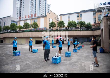 (210809) -- ZHANGJIAJIE, Aug. 9, 2021 (Xinhua) -- Delivery couriers have a morning meeting in Yongding District of Zhangjiajie, central China's Hunan Province, Aug. 9, 2021. Since last Tuesday, all the people in the central Chinese city of Zhangjiajie, including residents and tourists, are not allowed to leave the city as part of efforts to curb the latest resurgence of COVID-19. Local authorities have prioritized delivery services to ensure the supply of necessities. Credit: Xinhua/Alamy Live News Stock Photo