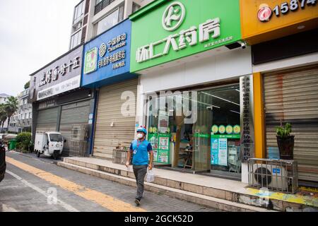 (210809) -- ZHANGJIAJIE, Aug. 9, 2021 (Xinhua) -- Delivery man Yan Yingzhao leaves a pharmacy for a medicine delivery order in Yongding District of Zhangjiajie, central China's Hunan Province, Aug. 9, 2021. Since last Tuesday, all the people in the central Chinese city of Zhangjiajie, including residents and tourists, are not allowed to leave the city as part of efforts to curb the latest resurgence of COVID-19. Local authorities have prioritized delivery services to ensure the supply of necessities. Credit: Xinhua/Alamy Live News Stock Photo