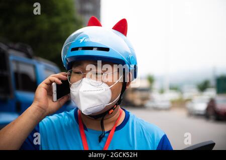 (210809) -- ZHANGJIAJIE, Aug. 9, 2021 (Xinhua) -- Delivery man Yan Yingzhao calls a resident to pick up a delivery order in Yongding District of Zhangjiajie, central China's Hunan Province, Aug. 9, 2021. Since last Tuesday, all the people in the central Chinese city of Zhangjiajie, including residents and tourists, are not allowed to leave the city as part of efforts to curb the latest resurgence of COVID-19. Local authorities have prioritized delivery services to ensure the supply of necessities. Credit: Xinhua/Alamy Live News Stock Photo