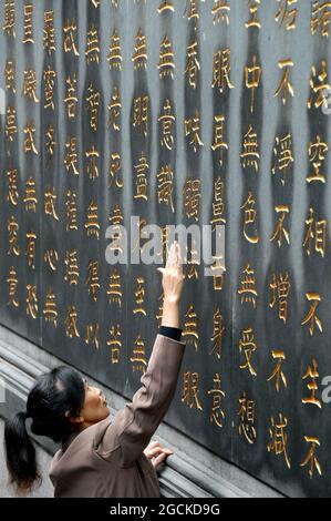 Lingyin Temple also known as the Temple of the Soul's Retreat in Hangzhou, China. Chinese characters where worshipers try to reach as high as they can Stock Photo