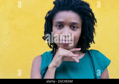 Portrait of young African Woman with afro hairstyle leaning on a wall Stock Photo