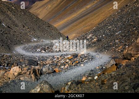 Remote view of hiker walking on sandy trail during trekking in Himalayas mountains in Nepal Stock Photo