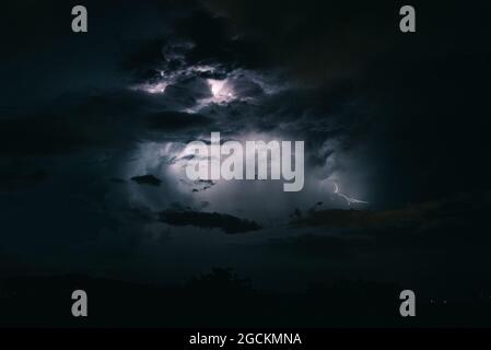 Storm sky with lightning among the dark and dramatic clouds Stock Photo
