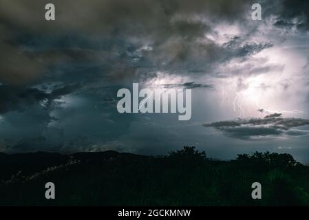 Storm sky with lightning among the dark and dramatic clouds Stock Photo