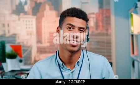 Close-up shot of mixed-race customer service operator talking to client in call center with skyscrapers in the background. Stock Photo