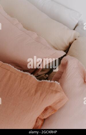 From above of full frame background of soft pillows of pastel colors placed in row on bed Stock Photo