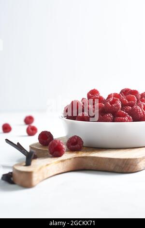 Side view of raspberries in a bowl on a wood isolated on a white background Stock Photo