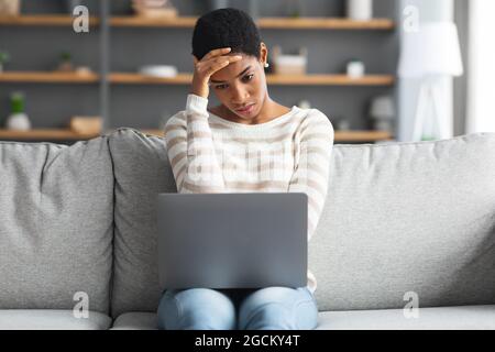 Stressed African American Woman Looking At Laptop Screen At Home Stock Photo