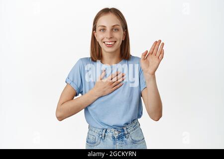 Happy and excited blond young woman, hold hand on chest and raise palm up,  promise, telling truth, introduce herself, greeting, my name is gesture Stock  Photo - Alamy