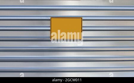 Blank yellow nameplate on a metal wall. Information, warning. Copy space Stock Photo