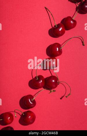 From above bright red appetizing cherries with stems on pink background Stock Photo