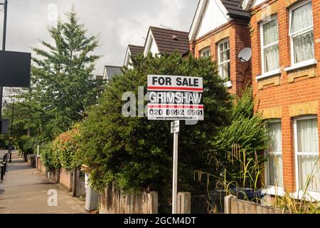 London August 2021: Estate agent for sale sign on street of houses on Pitsanger Lane in Ealing, West London Stock Photo