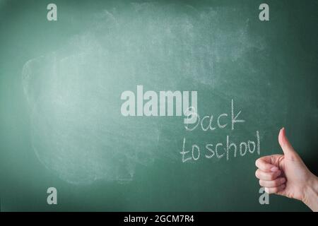 Female teachers hand writing on school board back to school white chalk. Concept back to school. Mock up for design. Copy space. Education Concept. Stock Photo