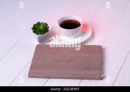 Copybook with cup of coffee and plant. Stock Photo