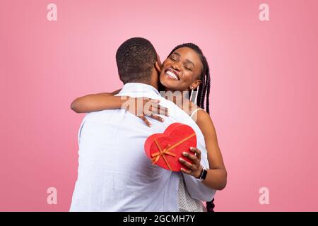 Happy black man making surprise for woman giving box Stock Photo