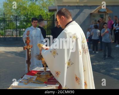 Kiev, Ukraine-April 29, 2018: Cleric with cloak polishing golden chalice before the ritual at the church.  ΙϹ ΧϹ HIKA, traditional abbreviation of the Stock Photo