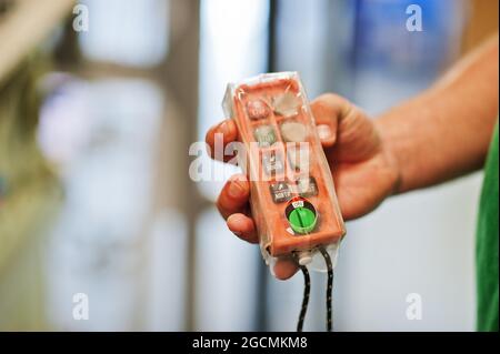 Technician show shutdown button on control panel in power plant. Stock Photo