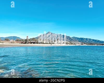 Puerto Banus, Marbella, Spain- July 21, 2020. Puerto Banus beach with blue sky and the shell behind. La Concha is the most famous mountain in Marbella Stock Photo