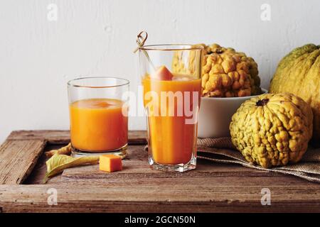 Two glasses of pumpkin smoothie and decorative pumpkins on a wooden table. Stock Photo