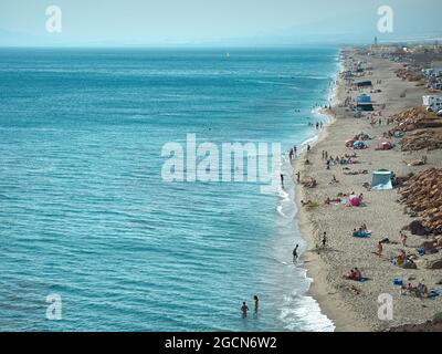 Almería, Spain-July 2, 2021. Las salinas beach full of tourists and people bathing in the Mediterranean Sea Stock Photo