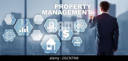 Businessman working on a virtual screen inscription: Property management. Stock Photo