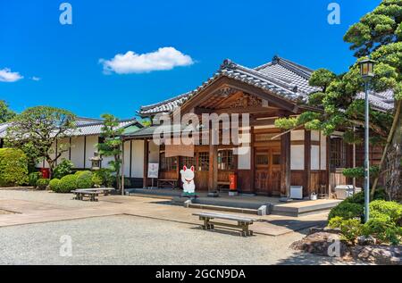 tokyo, japan - august 05 2021: Traditional buddhist office building in the gotokuji zen temple with a cardboard cutout depicting a Japanese manekineko Stock Photo