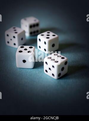 Five dice on a textured teal board.  Dramatic edit. Stock Photo