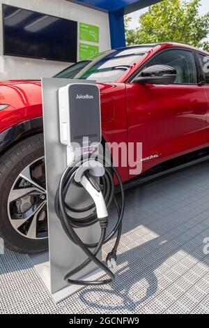 Detroit, Michigan - Ford's Mustang Mach-E 4X electric car, with a charging station, on display at the Motor City Car Crawl. The event, a mini-substitu Stock Photo
