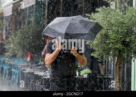 London, UK. 28th July, 2021. A man shelters under an umbrella from a heavy downpour in London as the wet weather continues. (Photo by Dinendra Haria/SOPA Images/Sipa USA) Credit: Sipa USA/Alamy Live News Stock Photo