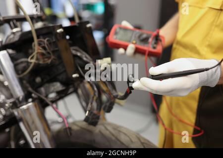 Electronics repair service master using multimeter tester to determine the problem part Stock Photo