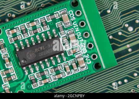 Macro close-up IC chip on small motion sensor circuit board pcb. Focus on lower components. Chip is a transmission signal processing control chip.