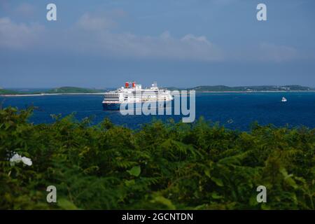 A cruise ship off the coast of St Mary's island, viewed from Garrison Hill, Isles of Scilly, Cornwall, England, UK, July 2021 Stock Photo