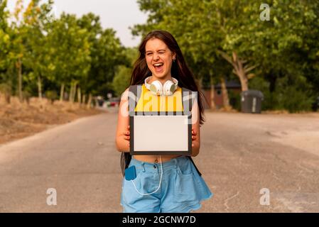 Young caucasian girl showing blank board in the park Stock Photo