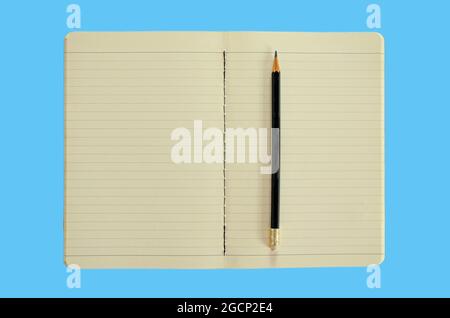 Open notebook with pencil isolated on blue background Stock Photo
